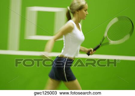 Side profile of a young woman playing tennis View Large Photo Image Stock Image - Side profile of a young woman playing tennis. Fotosearch