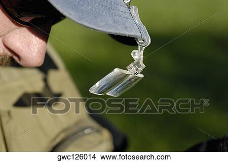 Close-up of a magnifying glass attached to a person's cap View Large Photo Image Picture - Close-up of a magnifying glass attached to a person's cap. Fotosearch