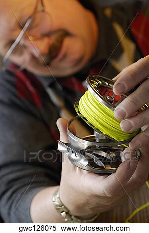 Close-up of a mature man looking at a fishing reel View Large Photo Image Stock Photography - Close-up of a mature man looking at a fishing reel. Fotosearch