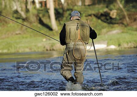 Rear view of a man fishing in the river View Large Photo Image Stock Image - Rear view of a man fishing in the river. Fotosearch