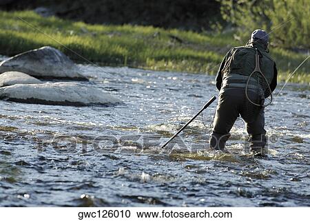 Rear view of a man fishing in the river View Large Photo Image Stock Image - Rear view of a man fishing in the river. Fotosearch