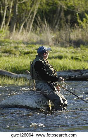 Side profile of a mature man fishing in the river View Large Photo Image Picture - Side profile of a mature man fishing in the river. Fotosearch