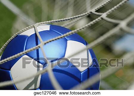 Stock Photograph - Close-up of a soccer ball in a net. Fotosearch