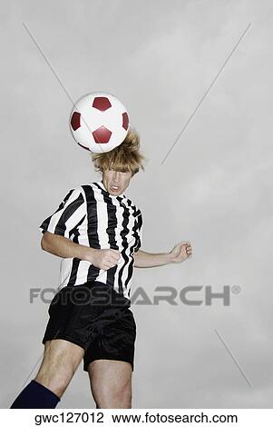 Low angle view of a soccer player heading a soccer ball View Large Photo Image Stock Image - Low angle view of a soccer player heading a soccer ball. Fotosearch