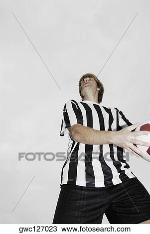Low angle view of a soccer player holding a soccer ball View Large Photo Image Stock Image - Low angle view of a soccer player holding a soccer ball. Fotosearch