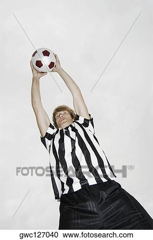 Low angle view of a soccer player holding a soccer ball over his head View Large Photo Image Stock Image - Low angle view of a soccer player holding a soccer ball over his head. Fotosearch