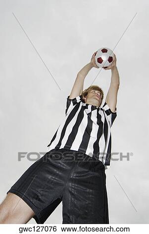 Low angle view of a soccer player holding a soccer ball over his head View Large Photo Image Stock Photograph - Low angle view of a soccer player holding a soccer ball over his head. Fotosearch