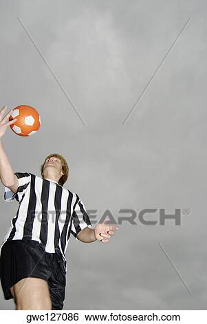 Low angle view of a soccer player tossing a soccer ball View Large Photo Image Stock Photograph - Low angle view of a soccer player tossing a soccer ball. Fotosearch