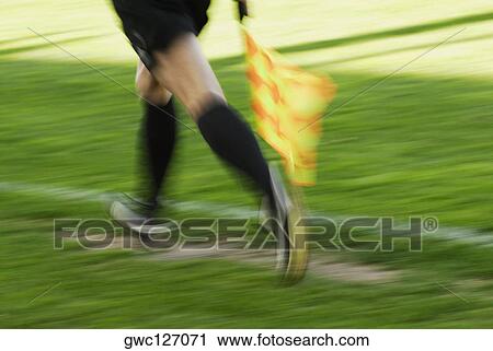 Low section view of a linesman running with a flag View Large Photo Image Stock Image - Low section view of a linesman running with a flag. Fotosearch