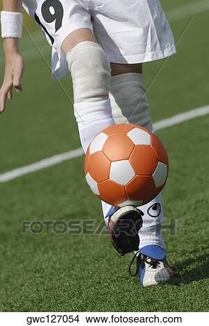 Low section view of a soccer player balancing a soccer ball View Large Photo Image Picture - Low section view of a soccer player balancing a soccer ball. Fotosearch