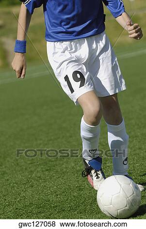 Low section view of a soccer player running with a soccer ball View Large Photo Image Stock Photo - Low section view of a soccer player running with a soccer ball. Fotosearch