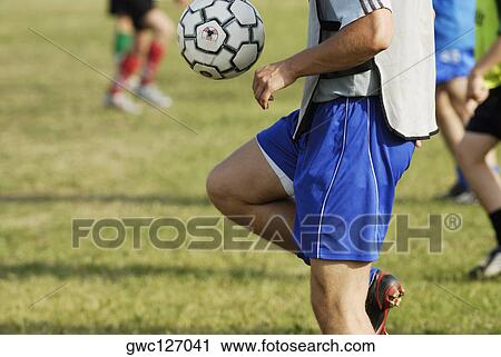 Mid section view of a soccer player balancing a soccer ball on his thighs View Large Photo Image Stock Image - Mid section view of a soccer player balancing a soccer ball on his thighs. Fotosearch