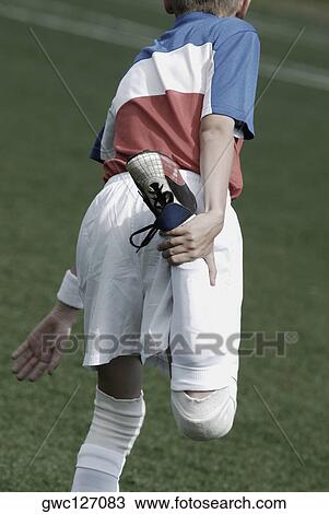 Rear view of a soccer player stretching his leg View Large Photo Image Stock Image - Rear view of a soccer player stretching his leg. Fotosearch