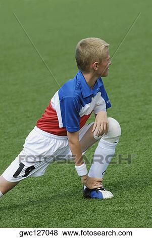 Soccer player stretching in a soccer field View Large Photo Image Stock Photo - Soccer player stretching in a soccer field. Fotosearch
