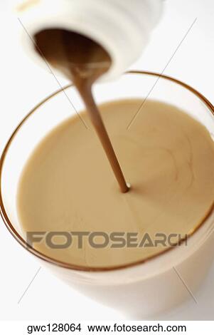 Chocolate milkshake pouring into a glass from a bottle View Large Photo Image Picture - Chocolate milkshake pouring into a glass from a bottle. Fotosearch