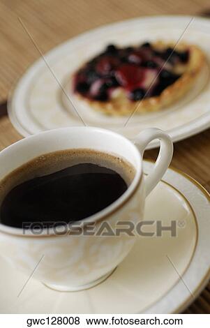 Close-up of a cup of black tea with a tart View Large Photo Image Stock Photo - Close-up of a cup of black tea with a tart. Fotosearch