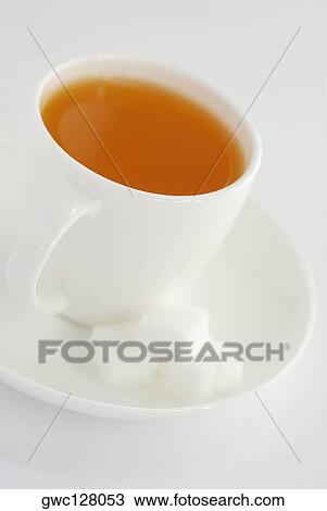 Close-up of a cup of herbal tea with sugar cubes on a saucer View Large Photo Image Stock Image - Close-up of a cup of herbal tea with sugar cubes on a saucer. Fotosearch