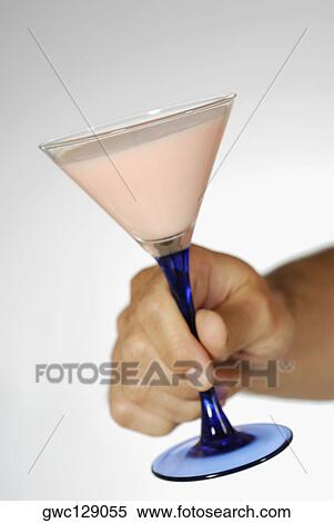 Close-up of a human hand holding a martini glass View Large Photo Image Stock Photography - Close-up of a human hand holding a martini glass. Fotosearch