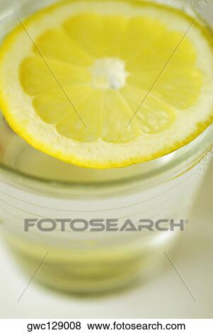 Close-up of a slice of lemon in a glass View Large Photo Image Stock Photo - Close-up of a slice of lemon in a glass. Fotosearch