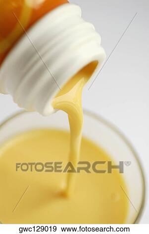 Milk pouring into a glass from a bottle View Large Photo Image Stock Photo - Milk pouring into a glass from a bottle. Fotosearch
