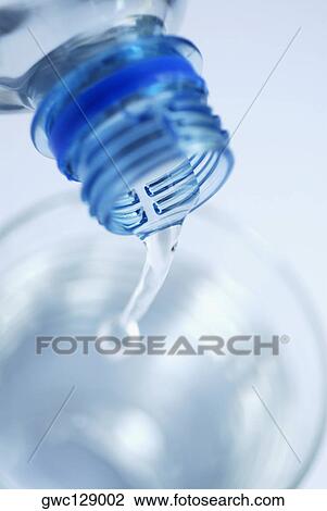 Water pouring from a bottle into a glass View Large Photo Image Stock Image - Water pouring from a bottle into a glass. Fotosearch