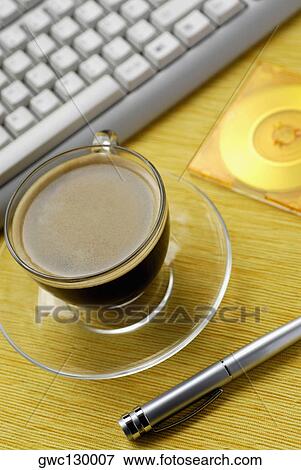 Stock Photo - Close-up of a cup of black coffee and a pen. Fotosearch