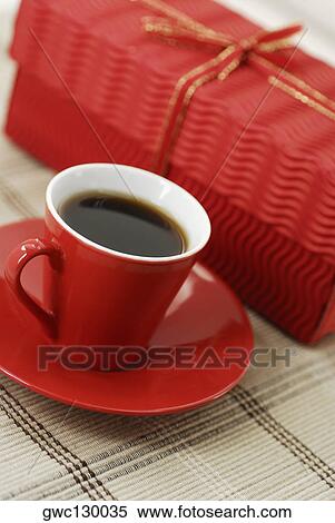 Close-up of a cup of black tea on a saucer with a gift View Large Photo Image Stock Photography - Close-up of a cup of black tea on a saucer with a gift. Fotosearch