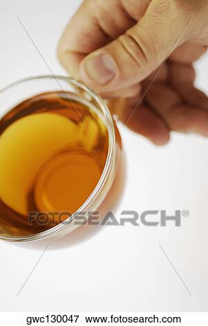 Close-up of a person's hand holding a cup of herbal tea View Large Photo Image Stock Photo - Close-up of a person's hand holding a cup of herbal tea. Fotosearch