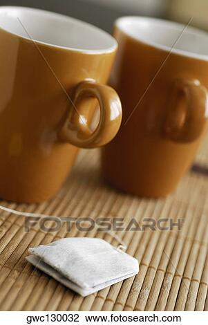 Close-up of two tea cups with a teabag on a bamboo mat View Large Photo Image Stock Image - Close-up of two tea cups with a teabag on a bamboo mat. Fotosearch