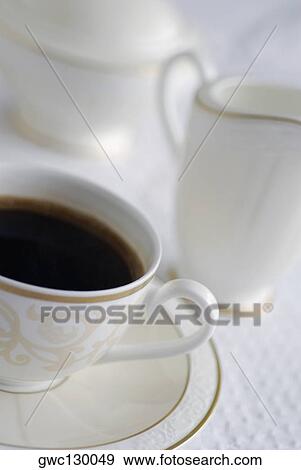 High angle view of a cup of black tea with a jug and a tea kettle View Large Photo Image Stock Photo - High angle view of a cup of black tea with a jug and a tea kettle. Fotosearch