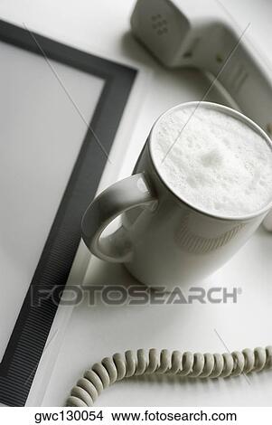 High angle view of a cup of coffee with a telephone receiver View Large Photo Image Picture - High angle view of a cup of coffee with a telephone receiver. Fotosearch