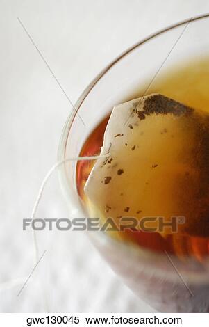 Stock Photography - High angle view of a teabag in a cup of herbal tea. Fotosearch