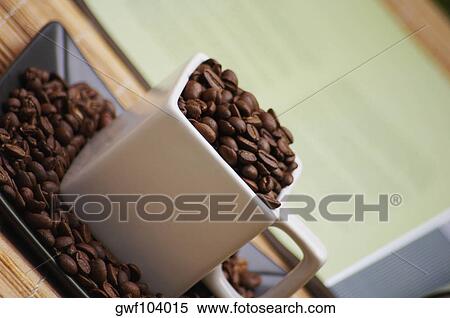 Stock Photography - High angle view of coffee beans in a cup. Fotosearch