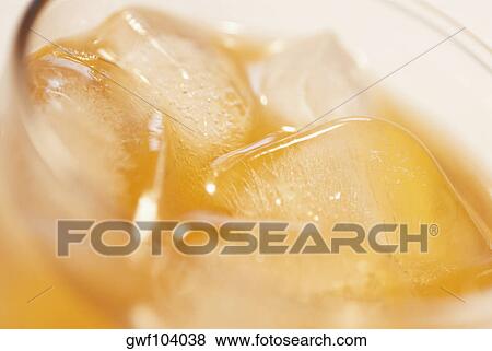High angle view of ice cubes in a glass of orange juice View Large Photo Image Stock Photo - High angle view of ice cubes in a glass of orange juice. Fotosearch