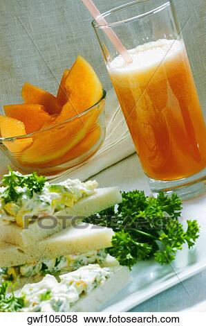 Close-up of a glass of juice and a bowl of fruit salad with a sandwich on a tray View Large Photo Image Stock Photo - Close-up of a glass of juice and a bowl of fruit salad with a sandwich on a tray. Fotosearch