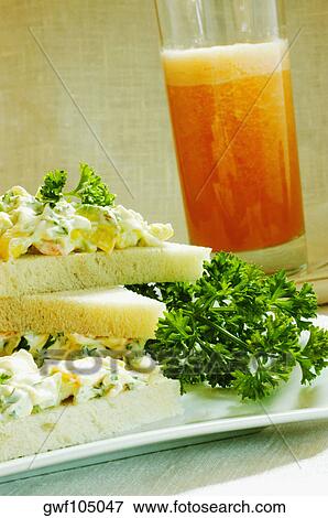 Close-up of a glass of juice with a sandwich on a tray View Large Photo Image Stock Photo - Close-up of a glass of juice with a sandwich on a tray. Fotosearch