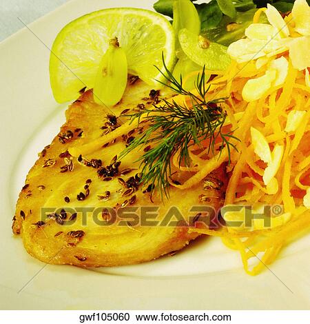 Stock Image - Close-up of a roast chicken with a lemon slice on a plate. Fotosearch
