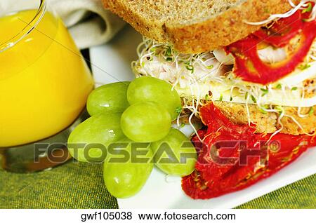 Stock Photo - Close-up of a sandwich with a glass of juice and grapes. Fotosearch