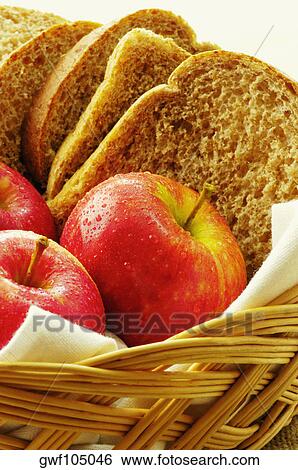 Stock Photograph - Close-up of apples and brown bread in a basket. Fotosearch