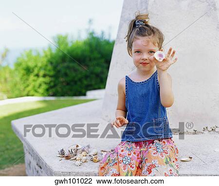 Portrait of a girl sitting and holding a shell, Bermuda View Large Photo Image Stock Image - Portrait of a girl sitting and holding a shell, Bermuda. Fotosearch