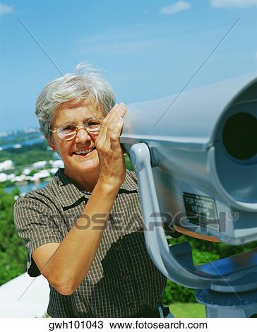 Portrait of a senior woman holding coin-operated binoculars and smiling, Bermuda View Large Photo Image Stock Image - Portrait of a senior woman holding coin-operated binoculars and smiling, Bermuda. Fotosearch