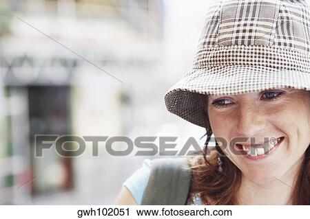 Close-up of a young woman wearing a hat View Large Photo Image Stock Image - Close-up of a young woman wearing a hat. Fotosearch