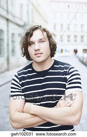 Portrait of a young man with his arms crossed View Large Photo Image Stock Image - Portrait of a young man with his arms crossed . Fotosearch