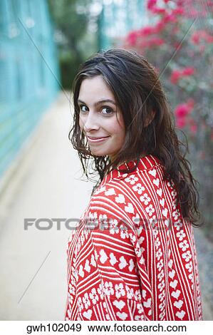 Stock Photo - Side profile of a young woman smiling. Fotosearch
