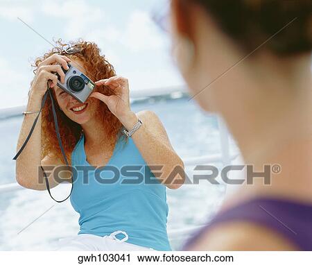 Close-up of a young woman taking a photograph of another woman, Bermuda View Large Photo Image Stock Image - Close-up of a young woman taking a photograph of another woman, Bermuda. Fotosearch