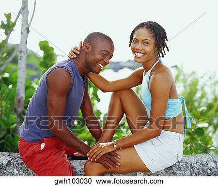 Portrait of a young woman sitting with a young man on a rock and smiling, Bermuda View Large Photo Image Stock Image - Portrait of a young woman sitting with a young man on a rock and smiling, Bermuda. Fotosearch