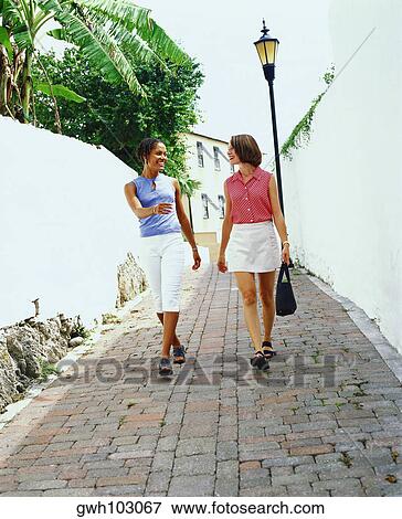 Two young women walking on a street, Bermuda View Large Photo Image Stock Photo - Two young women walking on a street, Bermuda. Fotosearch