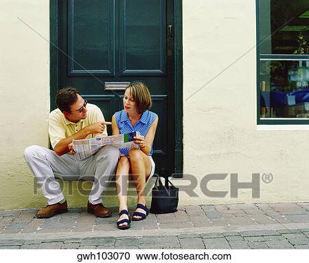 Young couple sitting in front of a door and holding a newspaper, Bermuda View Large Photo Image Stock Image - Young couple sitting in front of a door and holding a newspaper, Bermuda. Fotosearch