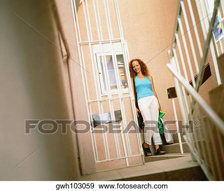 Young woman holding shopping bags and standing on a staircase, Bermuda View Large Photo Image Stock Photo - Young woman holding shopping bags and standing on a staircase, Bermuda. Fotosearch
