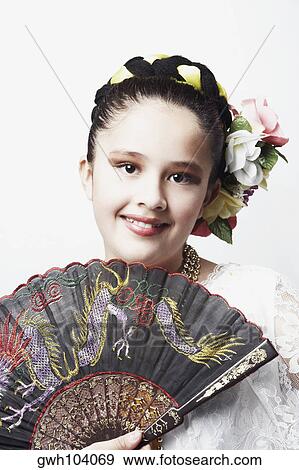 Portrait of a girl holding a folding fan and smiling View Large Photo Image Stock Photo - Portrait of a girl holding a folding fan and smiling. Fotosearch